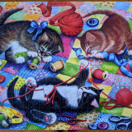 Knitting Kittens playing with yarns on quilt