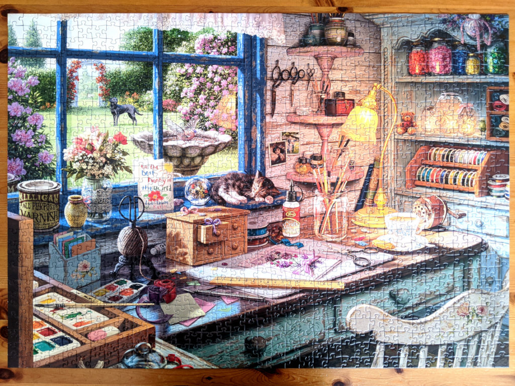 The Craft Shed shows the interior of a quaint shed packed with crafting supplies and tools with lovely view of a garden.
