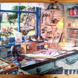 The Craft Shed shows the interior of a quaint shed packed with crafting supplies and tools with lovely view of a garden.